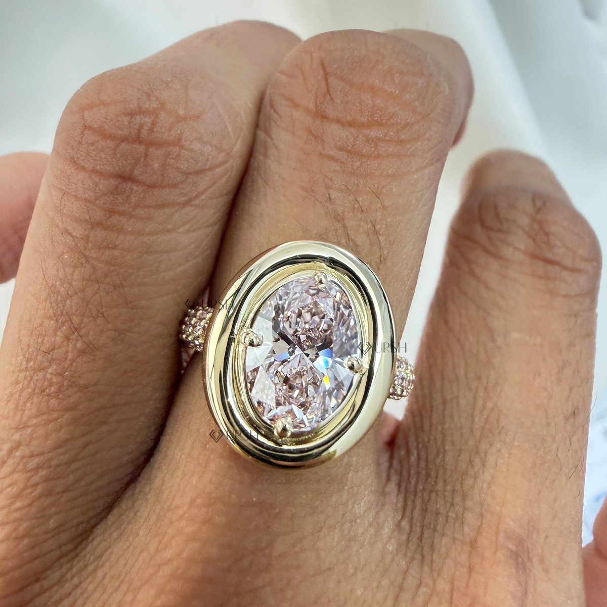 Oval pink diamond statement ring styled gracefully on finger in natural daylight