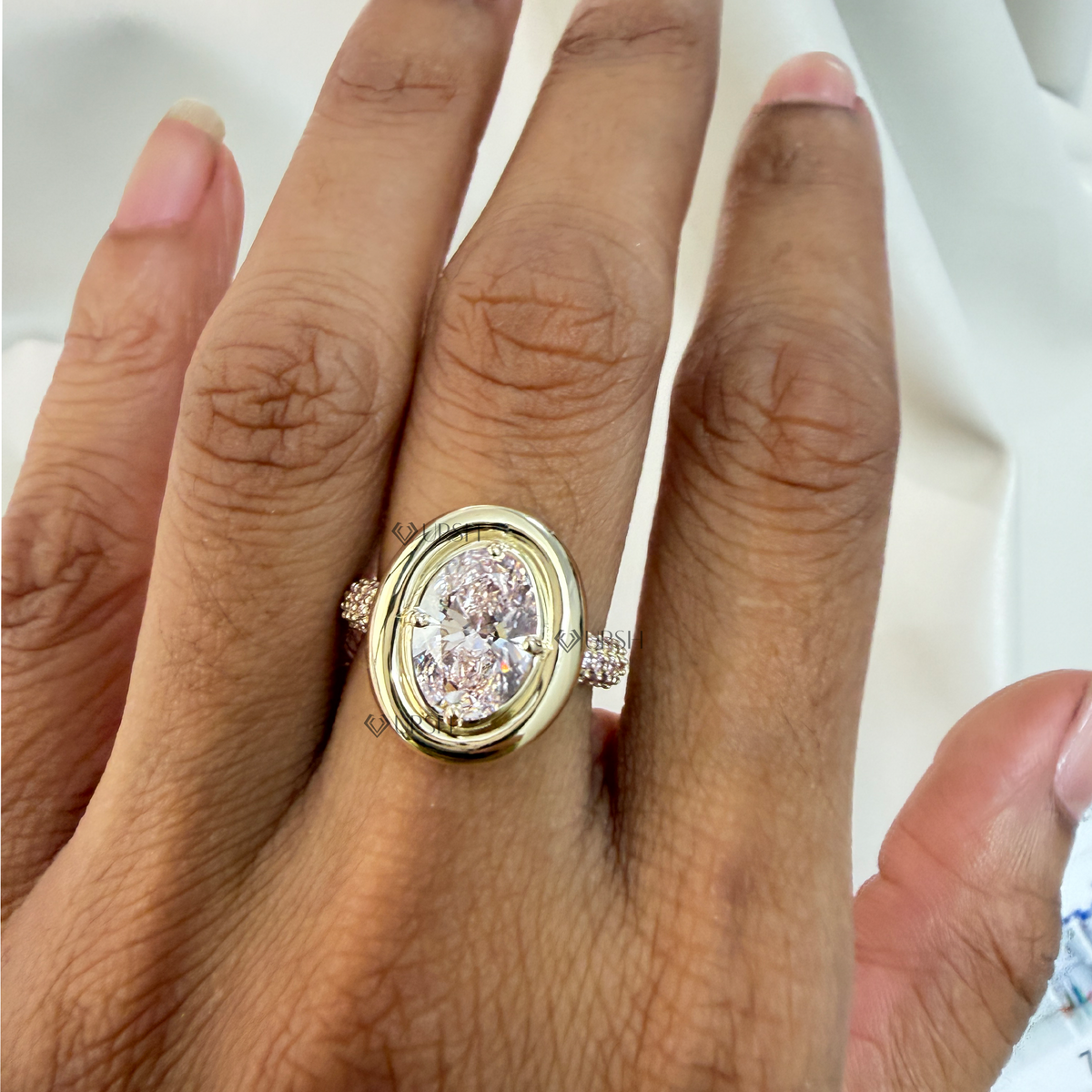 Daylight angle view of oval pink diamond cocktail ring worn on hand showcasing bold proportions