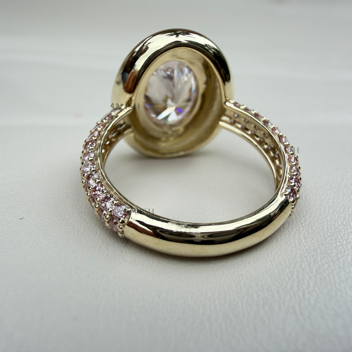 Studio view of yellow gold statement ring highlighting smooth mirror-polished bezel and pavé track