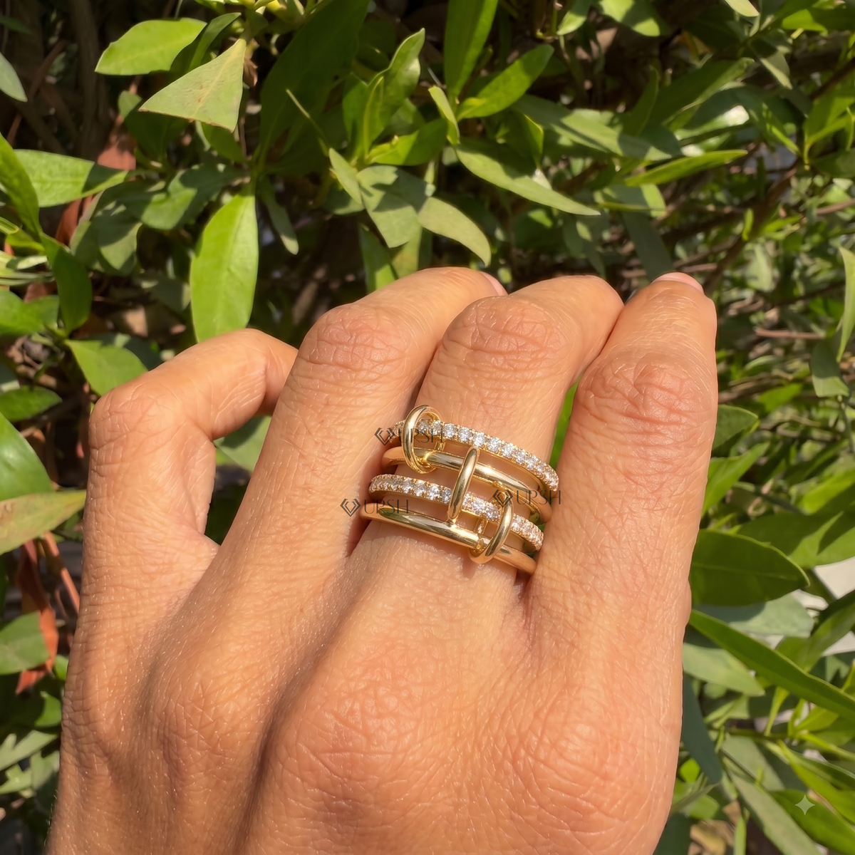 Multi-row architectural diamond link ring styled gracefully on finger in natural daylight