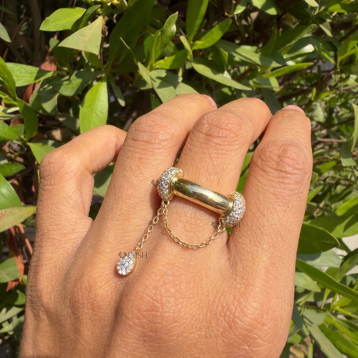Pavé diamond dangle chain statement ring styled gracefully on finger in natural daylight
