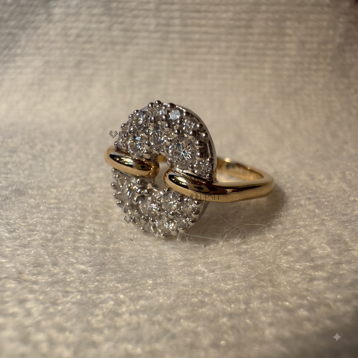 Angled studio shot of a two-tone circular cluster diamond statement ring on a textured white surface.