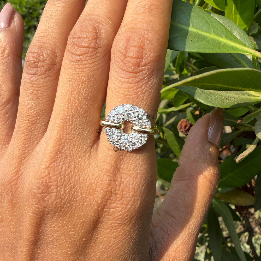 Bold circular pavé disc statement ring worn on finger, highlighting its striking design presence outdoors.
