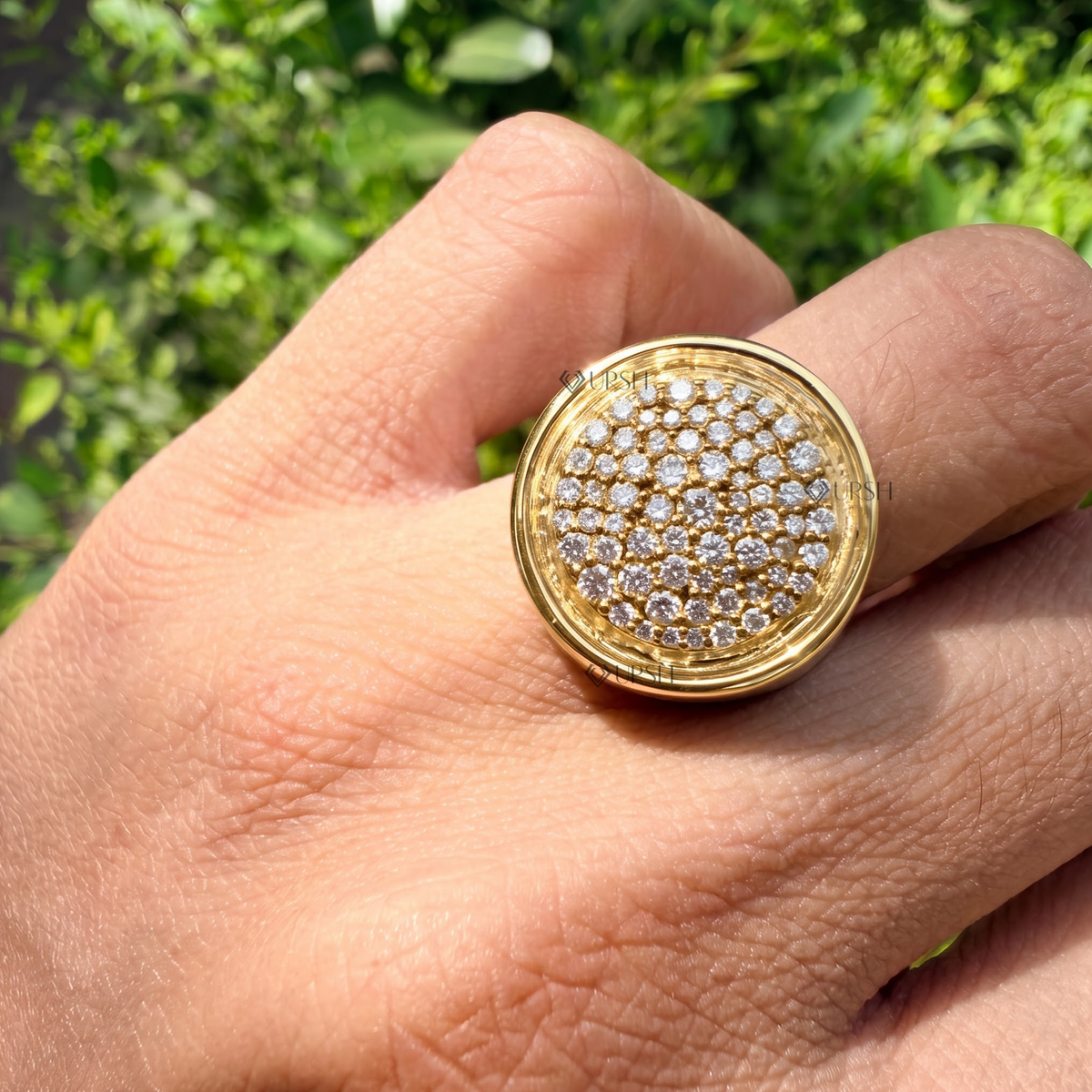 Circular pavé signet ring styled gracefully on finger in natural daylight