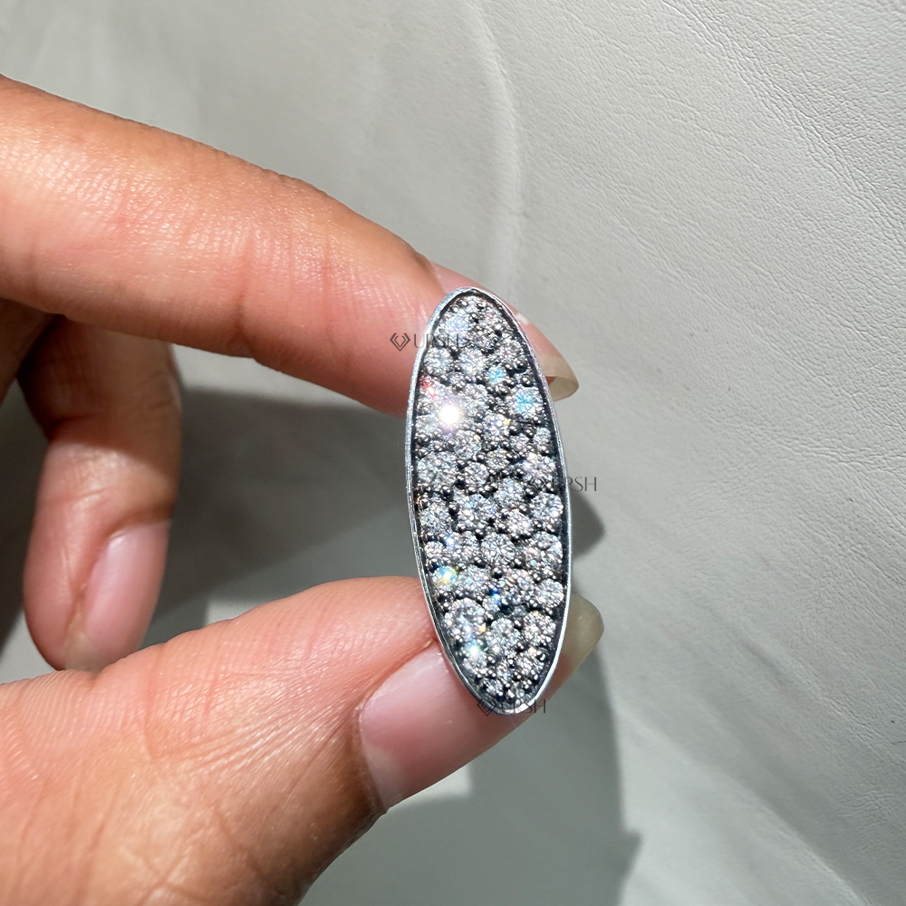 Close-up holding elongated oval shield ring displaying low profile flat disc structure