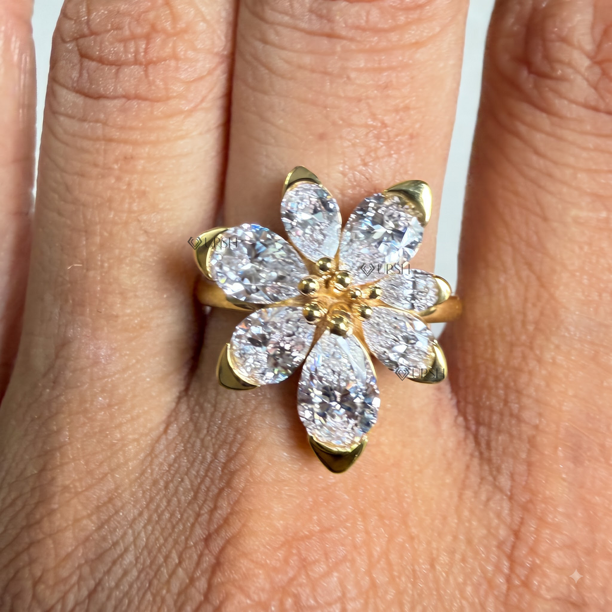 Yellow gold pear diamond blossom cocktail ring catching bright afternoon daylight