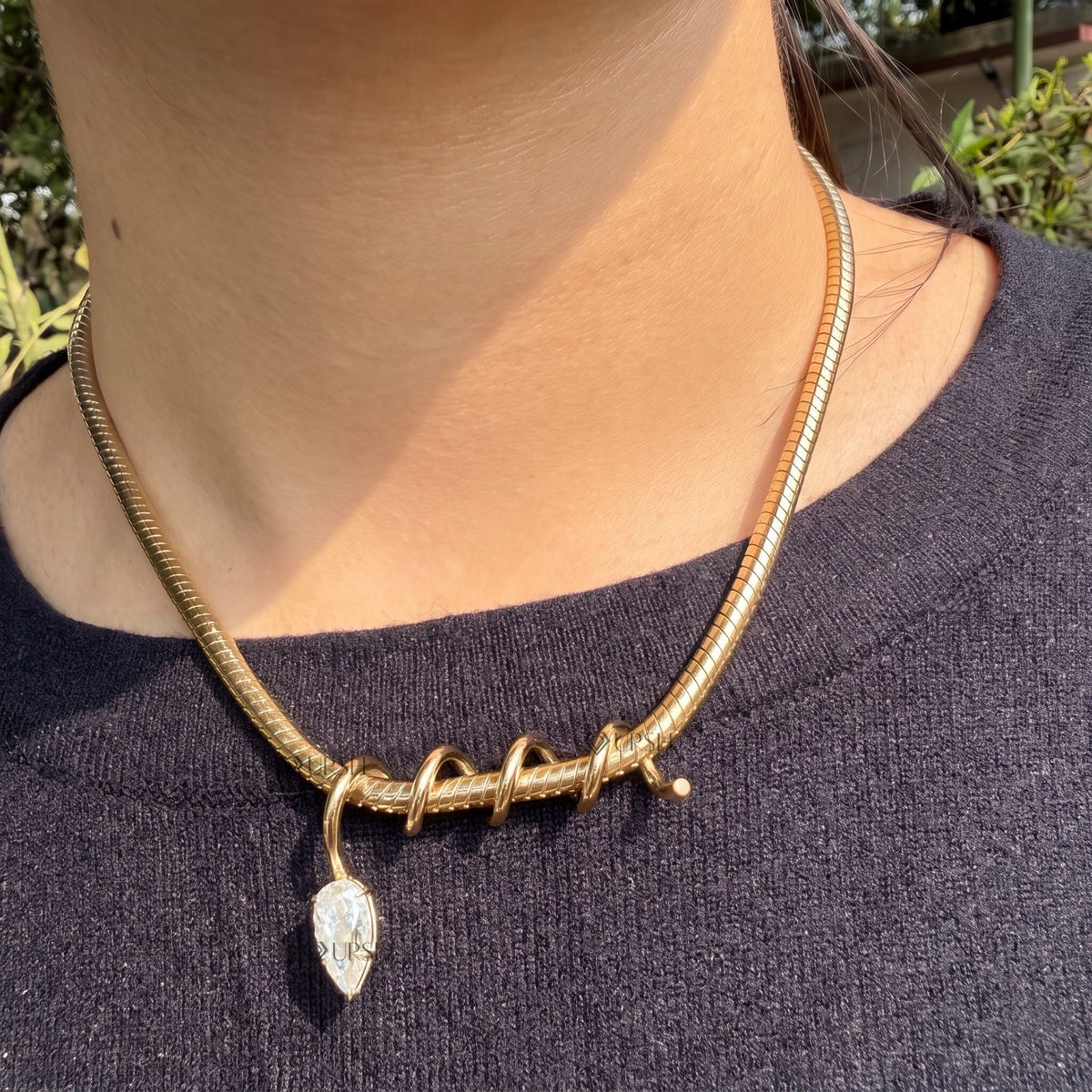 Yellow gold pear diamond spiral wire charm necklace styled gracefully on neck in natural daylight