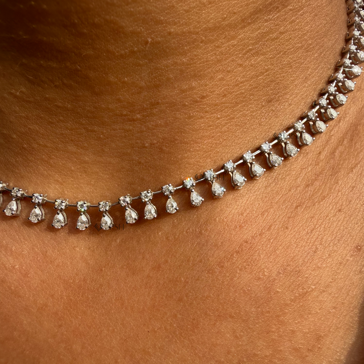 Daylight perspective of white gold pear diamond drop fringe necklace worn against collarbone