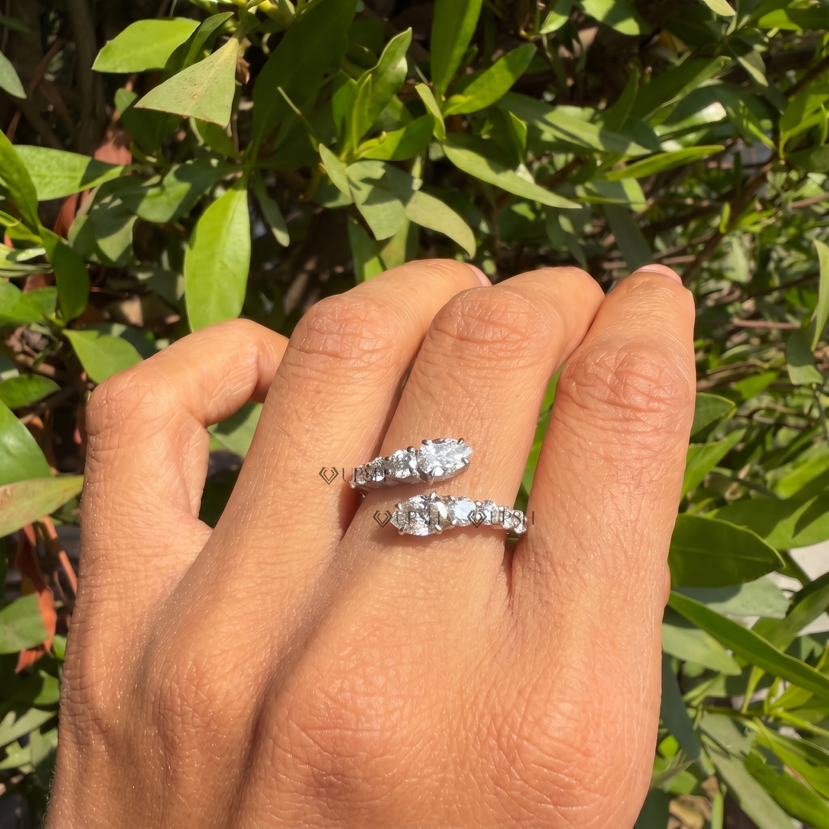 Daylight angle view of diamond bypass cluster ring worn on hand showcasing open silhouette