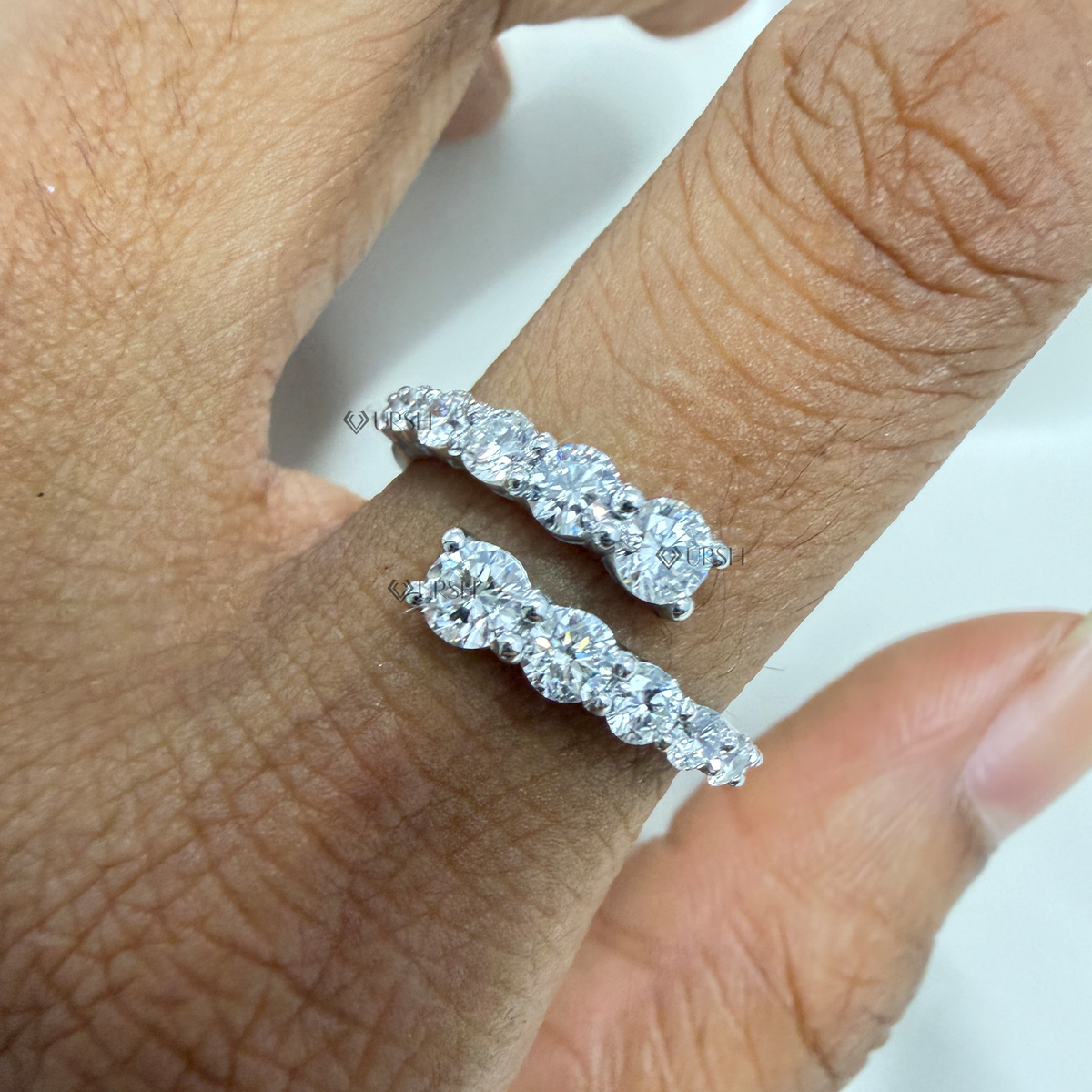 Graduated round lab grown diamond bypass wrap ring in solid yellow gold on finger