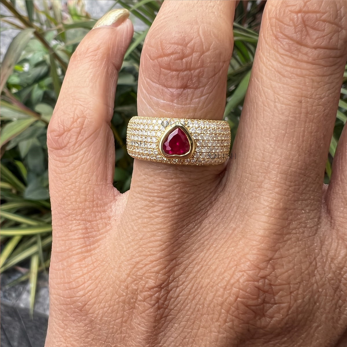 Heart ruby pavé diamond cigar band ring styled gracefully on finger in natural daylight