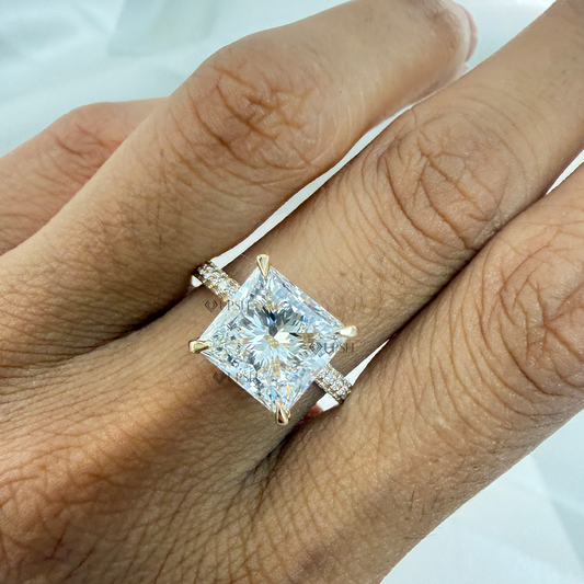 Detailed daylight close-up of radiant cut lab diamond solitaire with pavé band worn on hand