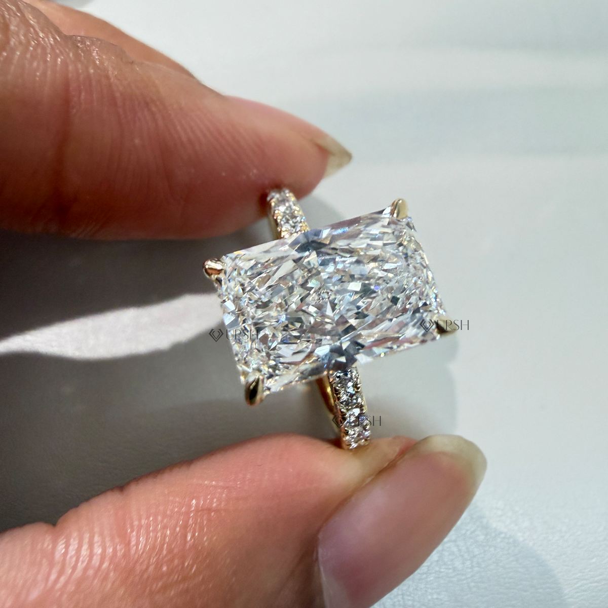 Detailed daylight macro close-up holding radiant cut solitaire ring to showcase facet brilliance