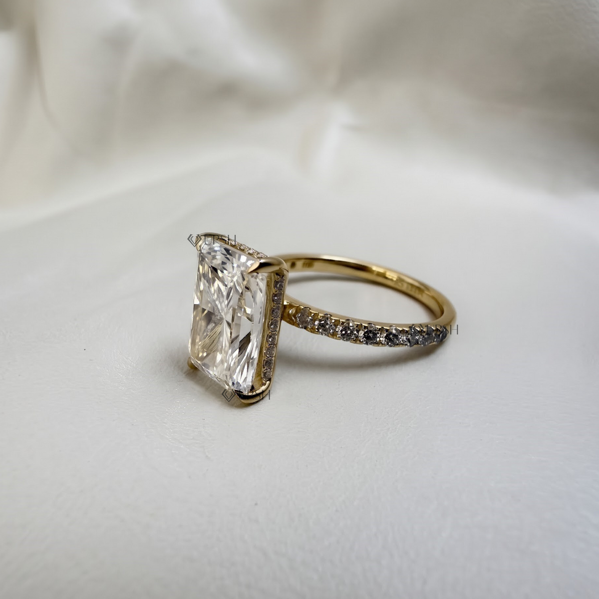 Studio profile view of yellow gold radiant ring displaying basket setting and pavé track