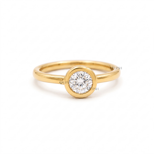Solid yellow gold modern engagement ring featuring a round brilliant lab grown diamond in a smooth bezel setting
