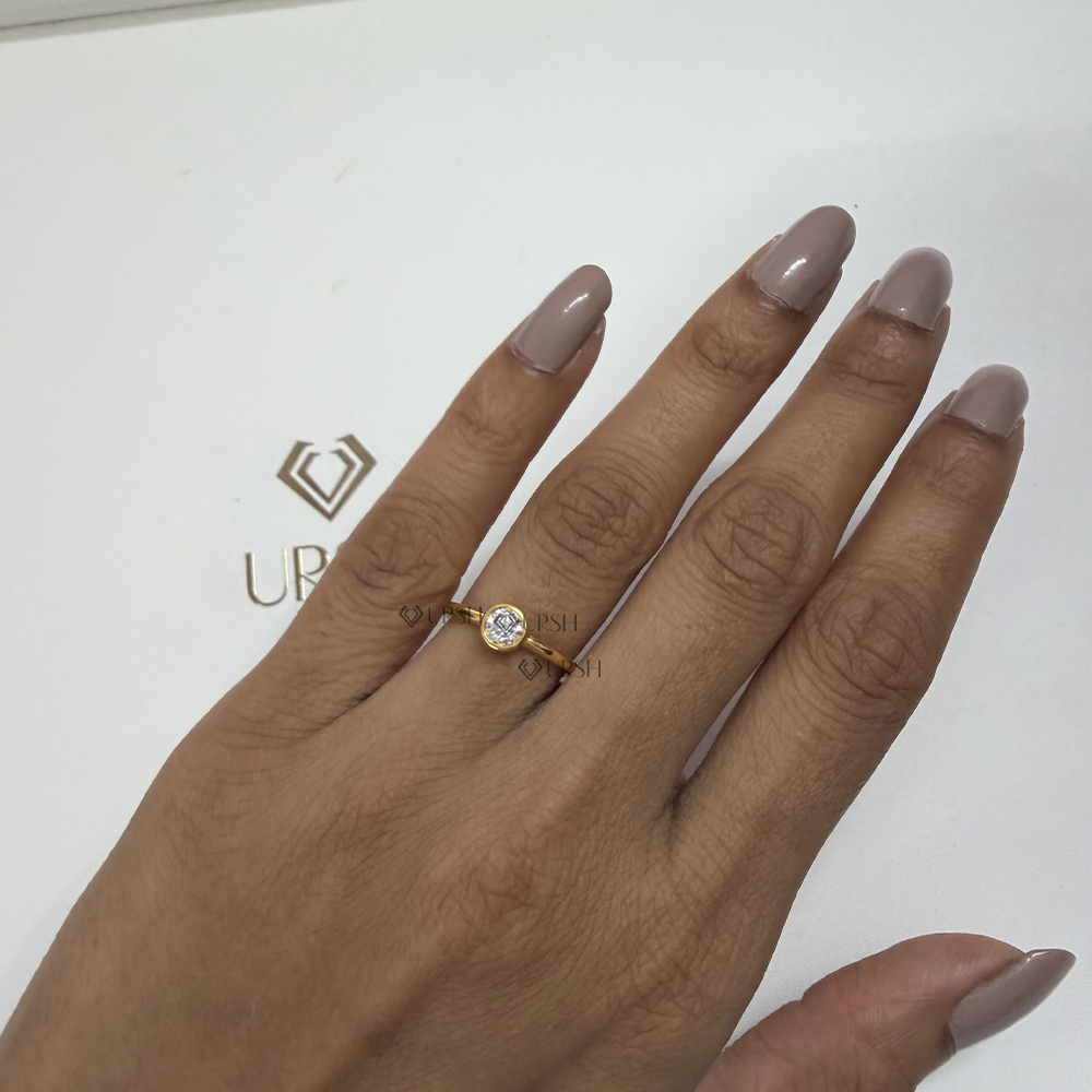 Classic yellow gold bezel set round diamond solitaire worn on hand showing low-profile fit