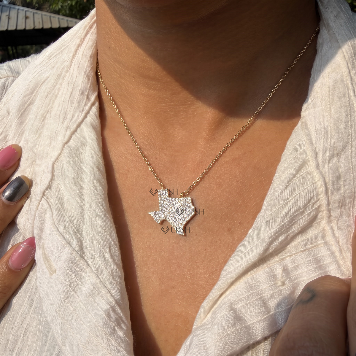 Daylight perspective view of white gold Texas state map diamond pendant resting along collarbone