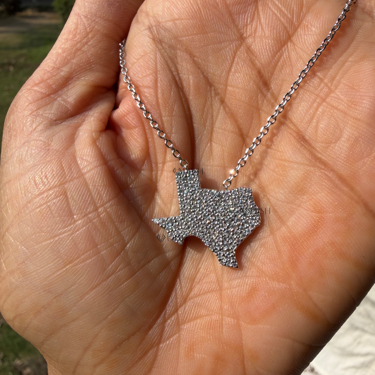 Detailed hand model view of solid white gold Texas state map pavé diamond pendant held gracefully