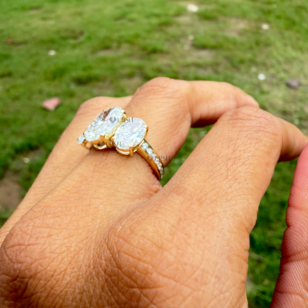 Yellow gold multi-stone oval diamond ring catching bright daylight on ring finger