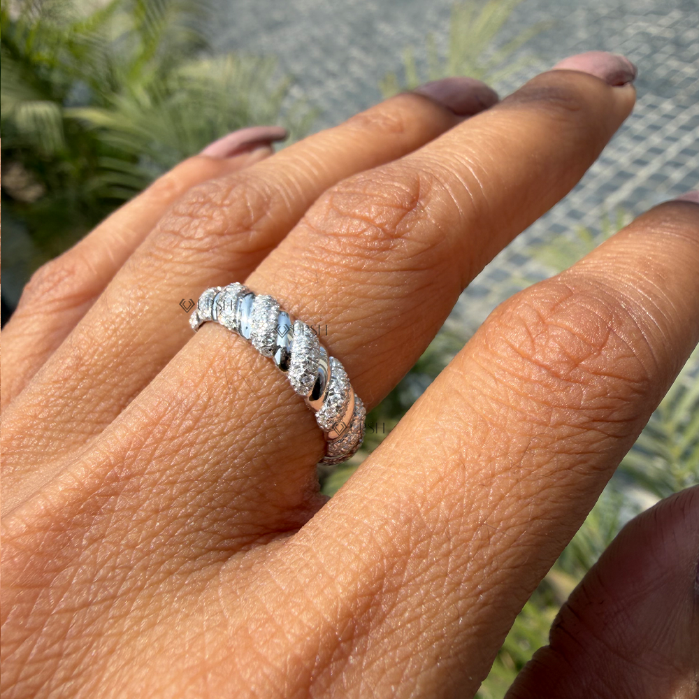 Substantial finger coverage of white gold pavé croissant wedding band in outdoor light