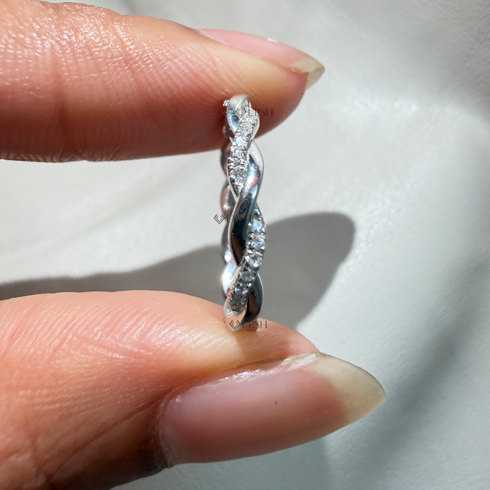 Detailed daylight macro close-up of alternating polished gold and micro-pavé diamond twisted strands worn on finger