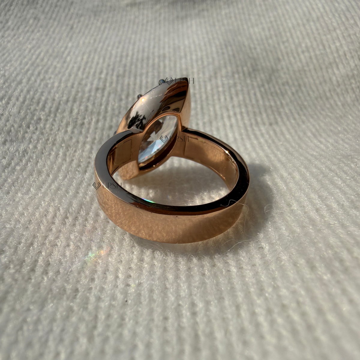 Studio view of rose gold wide cigar band showing flat flush profile and secure center prong basket