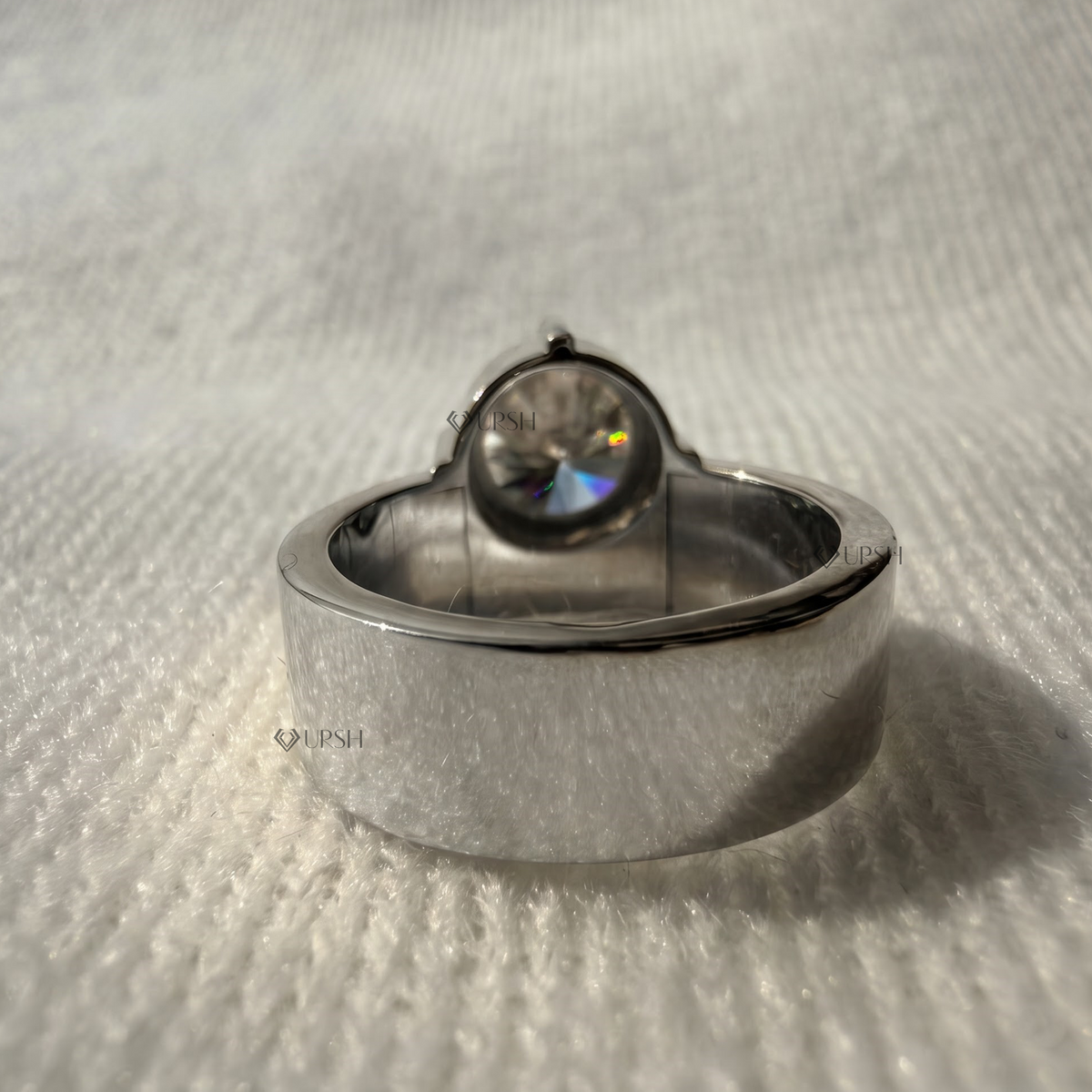 Studio view of white gold cigar band showing flat flush profile and secure center prong basket