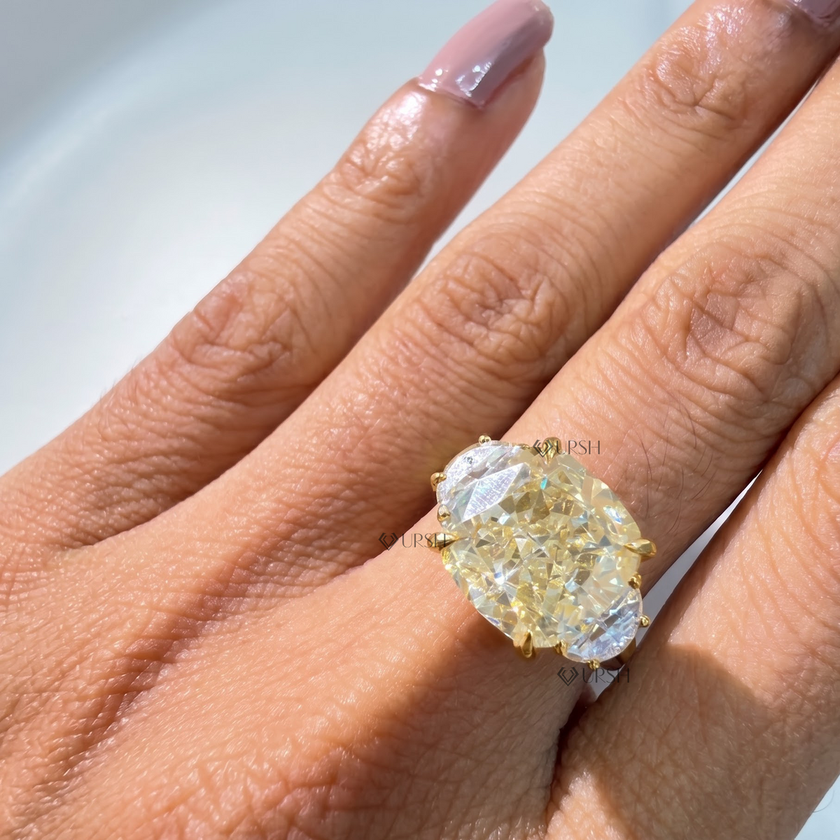Direct overhead view showing finger coverage of elongated cushion and curved half-moon side diamonds