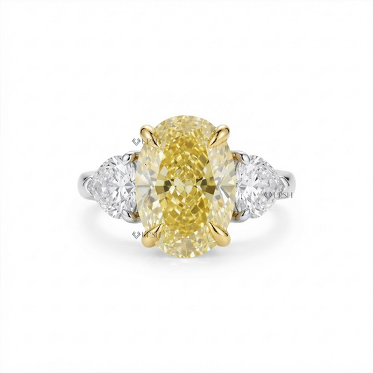 Solid two-tone gold three-stone engagement ring featuring a vivid canary yellow oval lab diamond flanked by pear side stones
