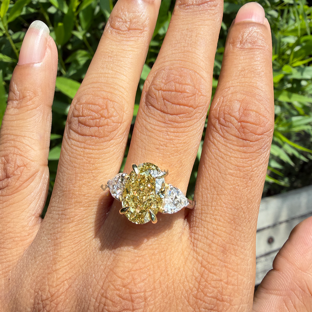 Impressive finger coverage and brilliance of three-stone yellow and white diamond ring worn outdoors