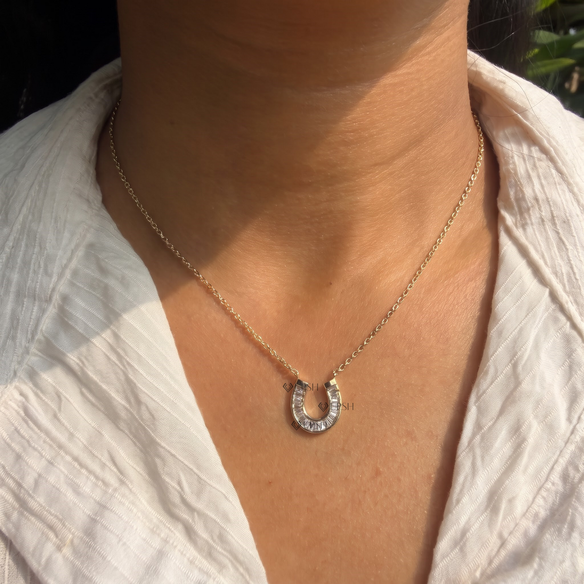 Daylight perspective of yellow gold horseshoe diamond pendant worn on neck