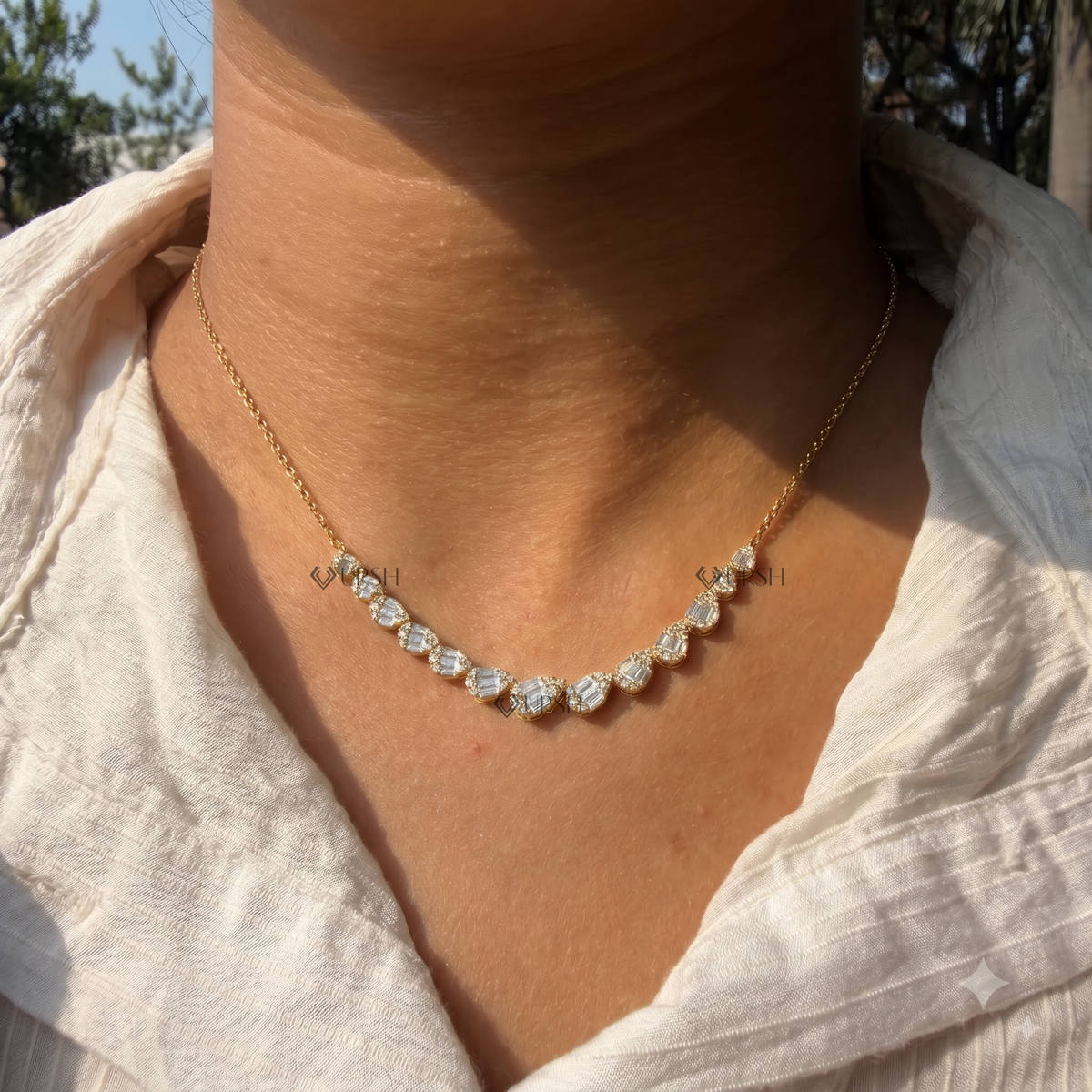 Daylight macro view of white gold graduated pear cluster diamond station necklace worn on neck