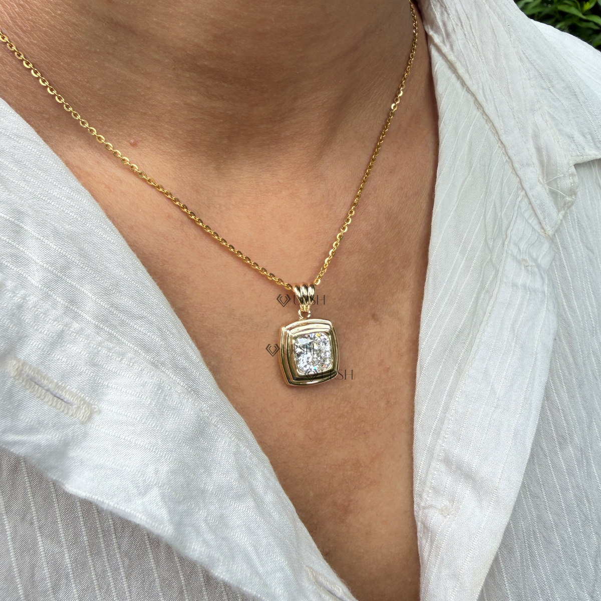 Yellow gold cushion cut bezel set solitaire pendant necklace styled gracefully on neck in natural daylight