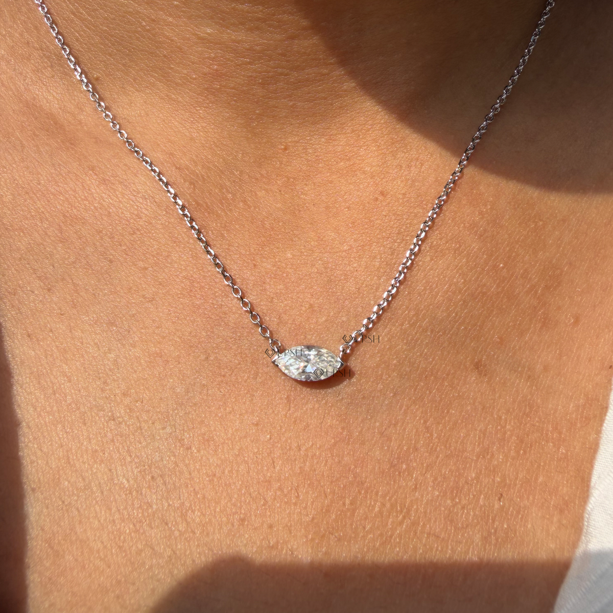 Daylight angle view of white gold horizontal marquise cut diamond solitaire pendant chain worn on neck