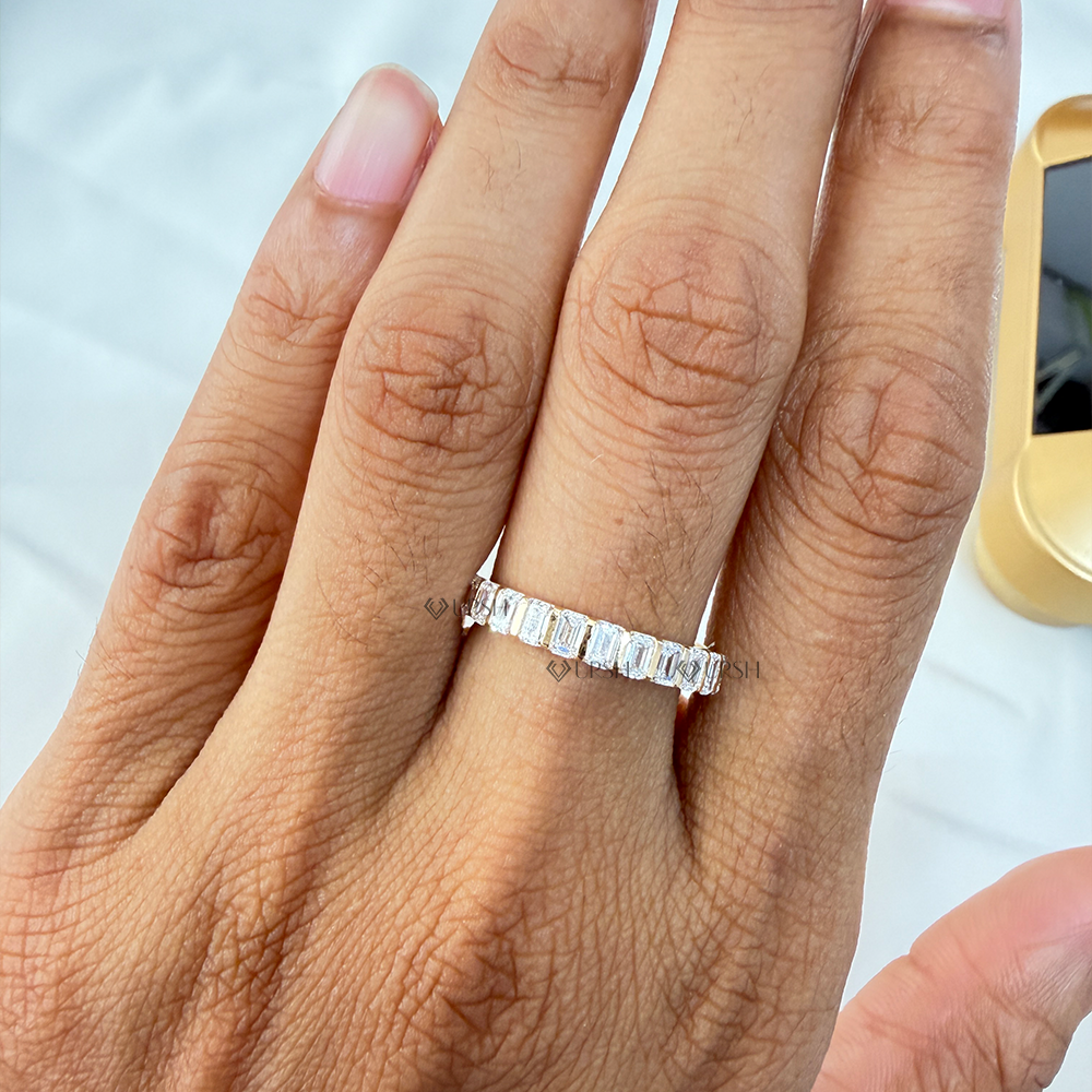 Sleek emerald cut diamond stackable eternity band styled on manicured hand