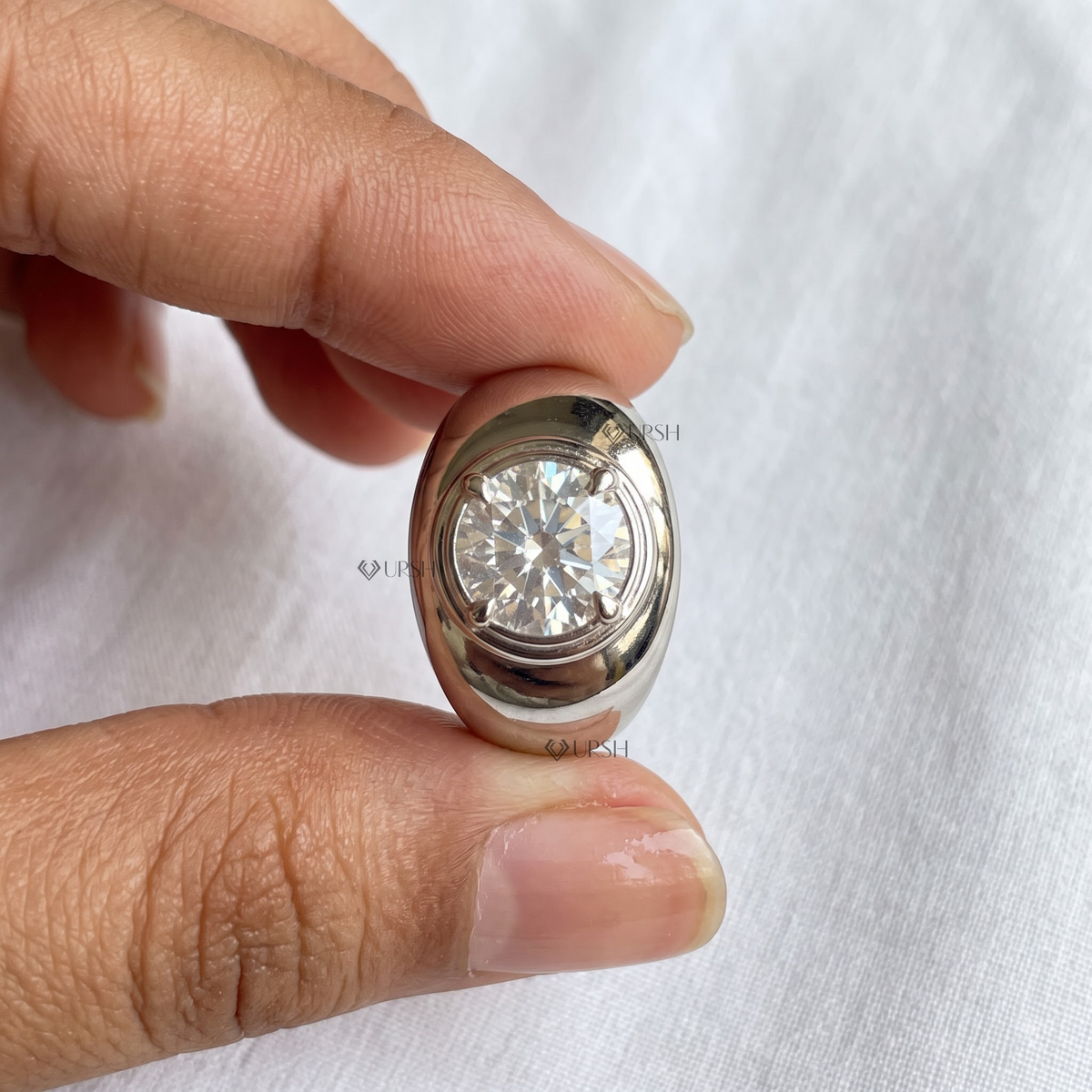 Detailed macro close-up holding solid white gold chunky dome ring to display mirror finish and center diamond