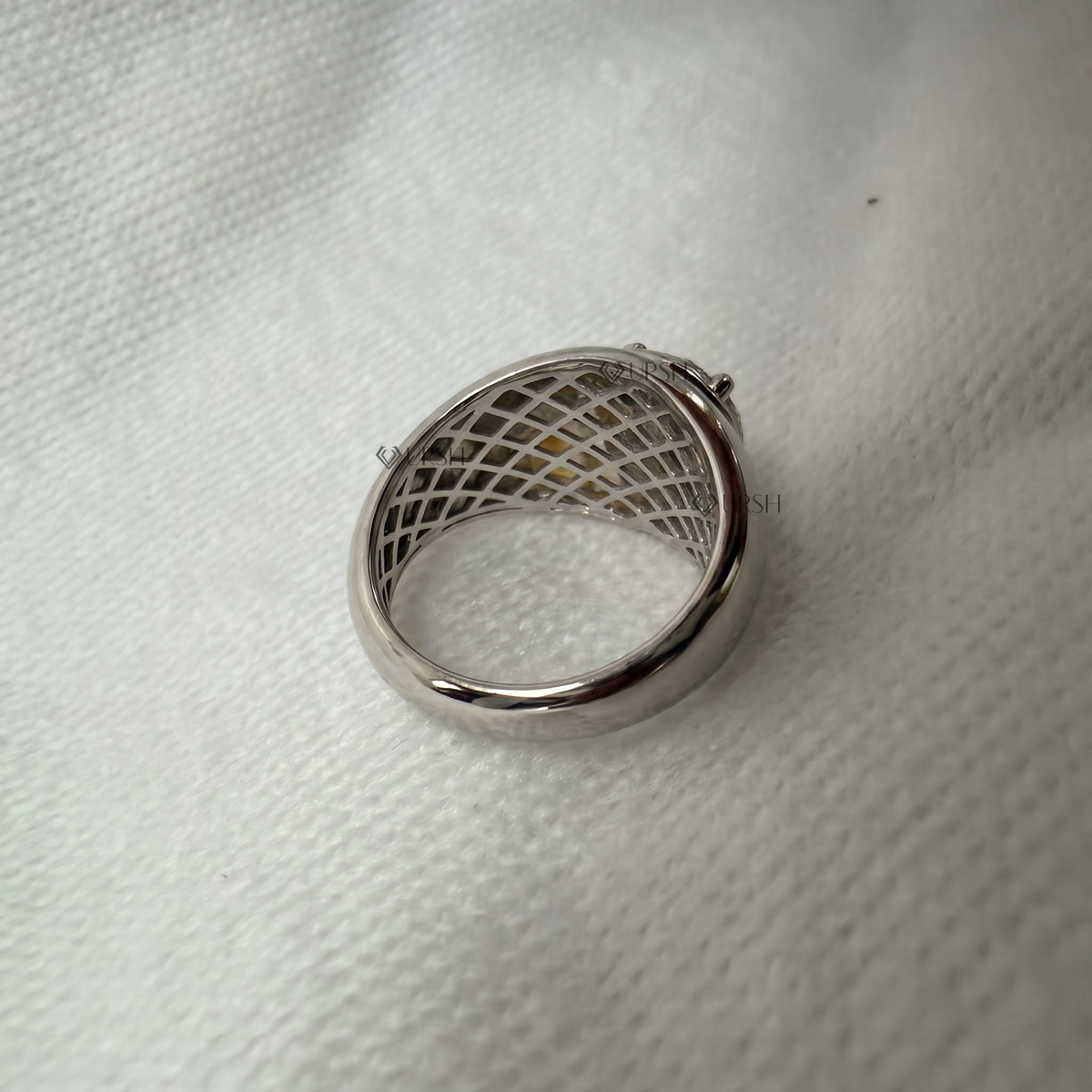 Under-finger view displaying honeycomb open-work gallery structure and solid comfort-fit band