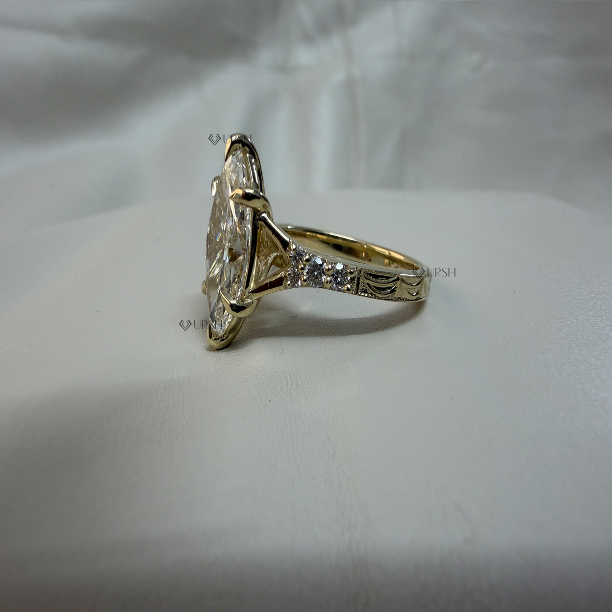 Side angle profile showing raised basket setting and sculpted under-gallery of marquise ring