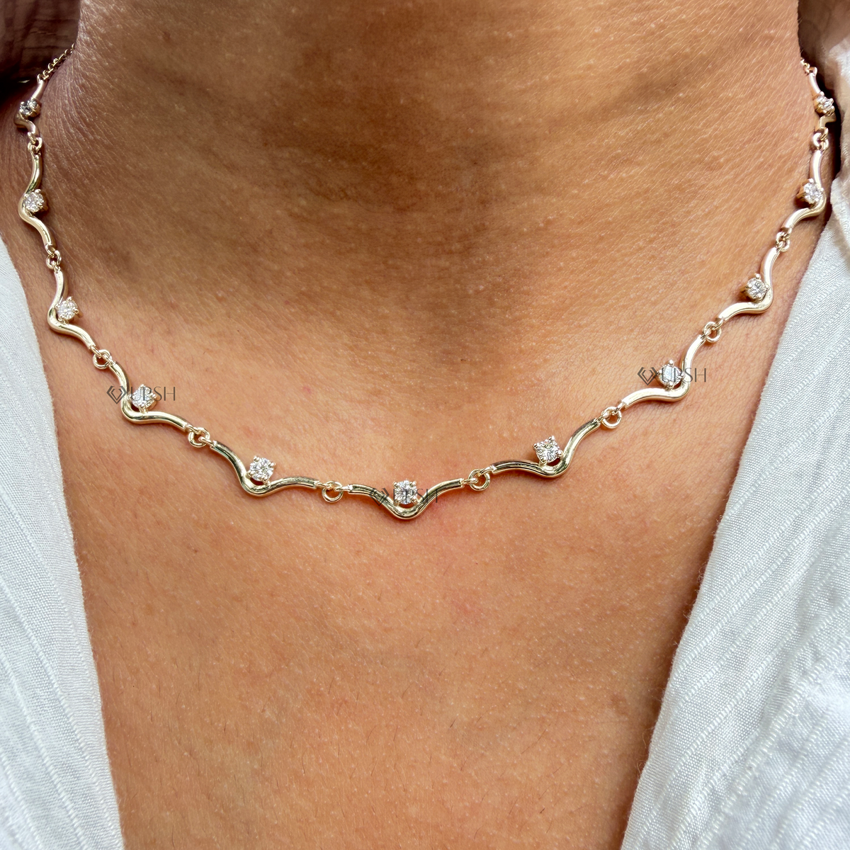 Detailed macro view of prong set round diamonds nested on solid gold wavy bar links