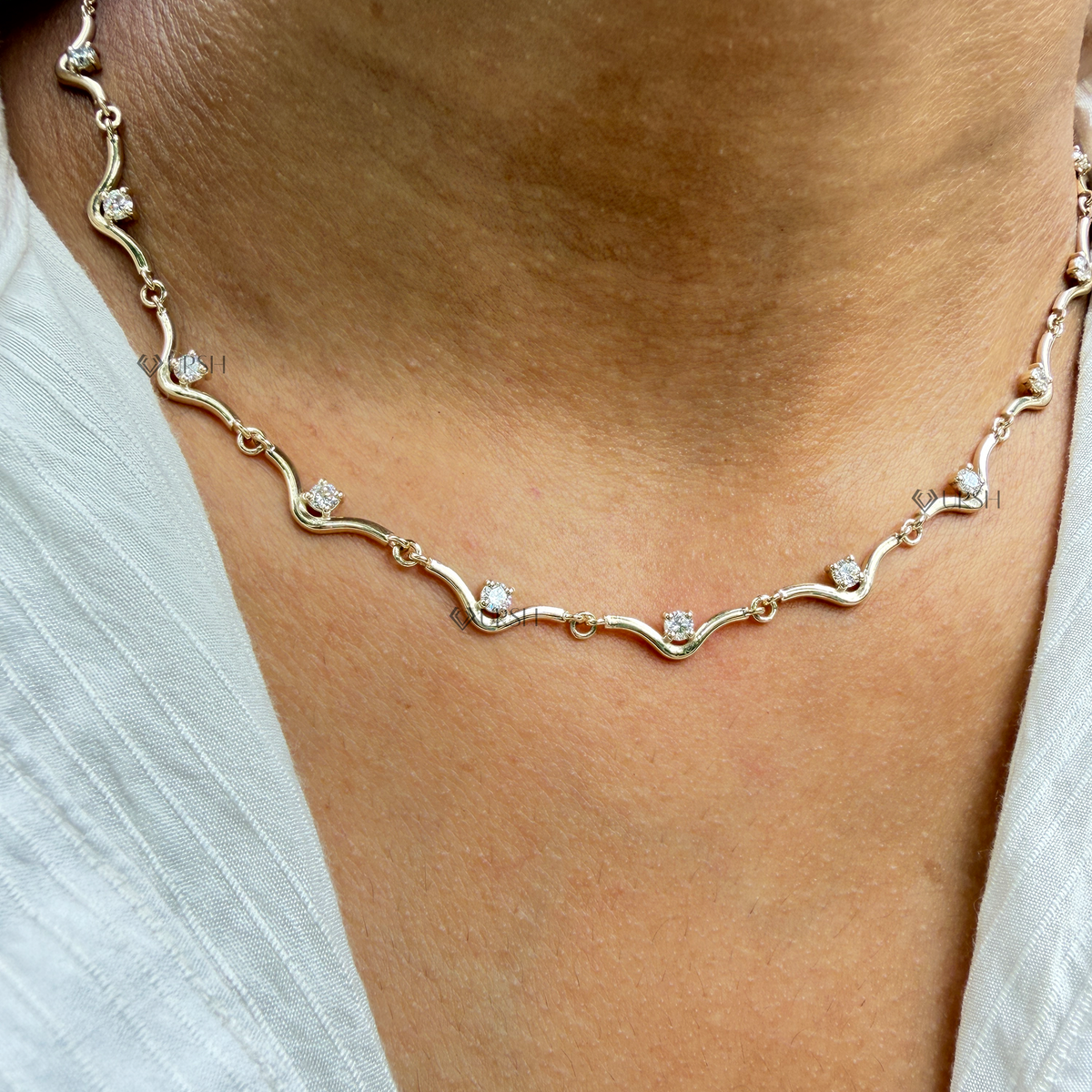 Yellow gold wavy link diamond station chain necklace styled gracefully on neck in natural daylight